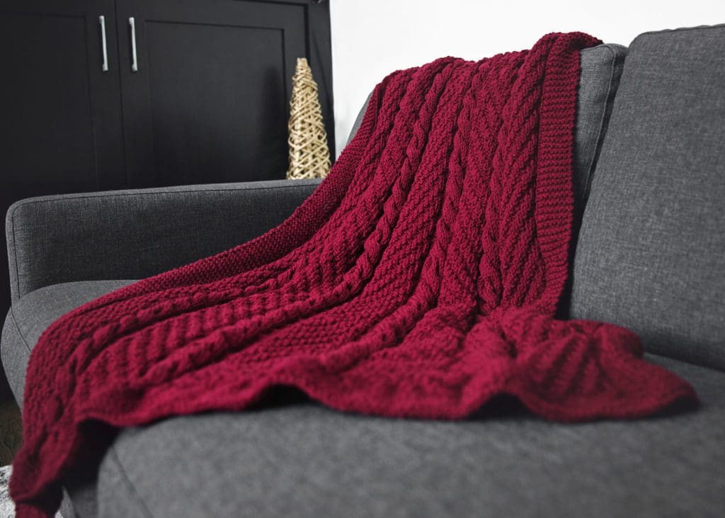 Cozy Cables Throw Blanket knitting pattern - photo of blanket on sofa